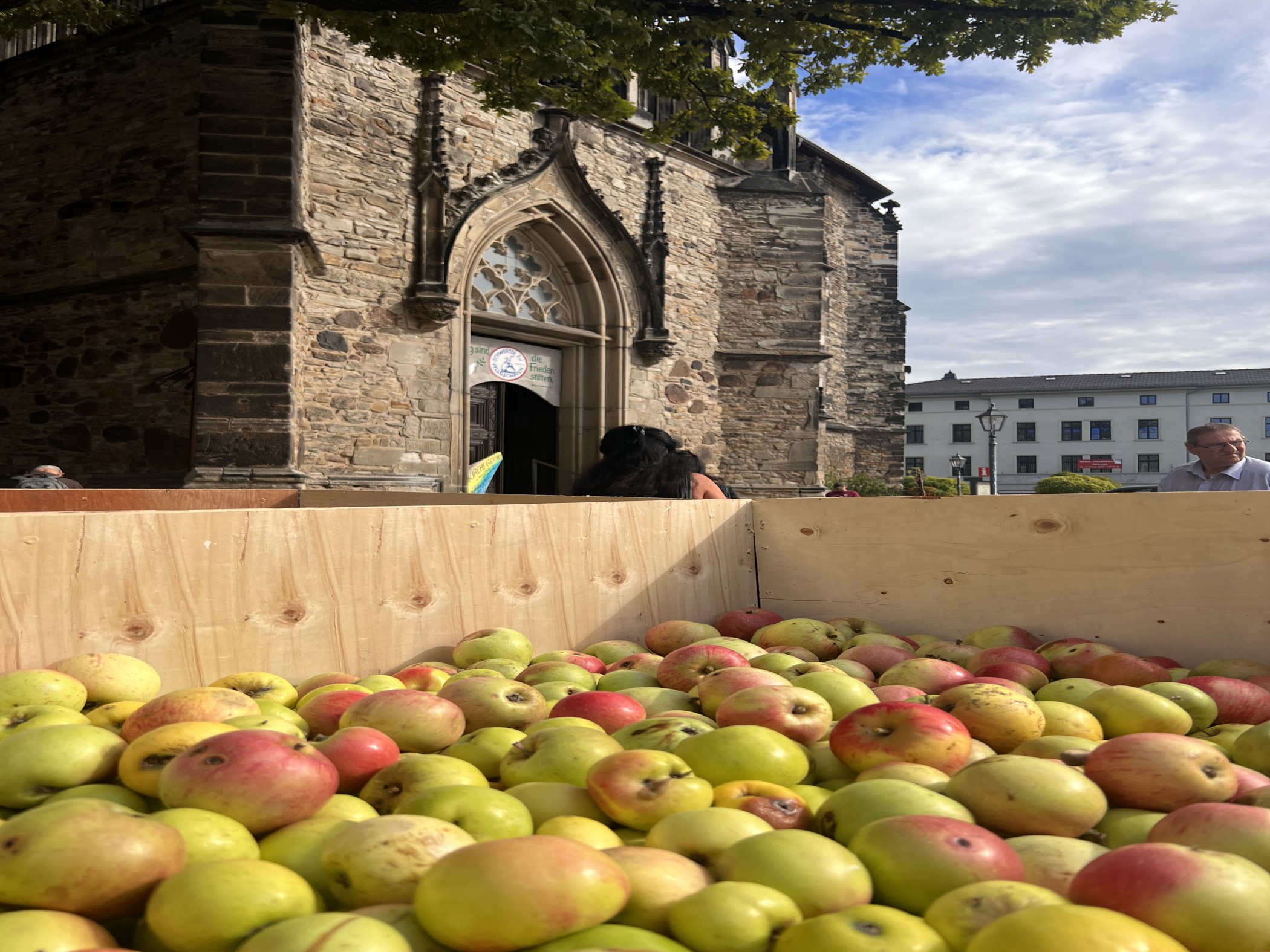 Äpfel in einem Anhänger vor dem Eingang der St. Jakobskirche