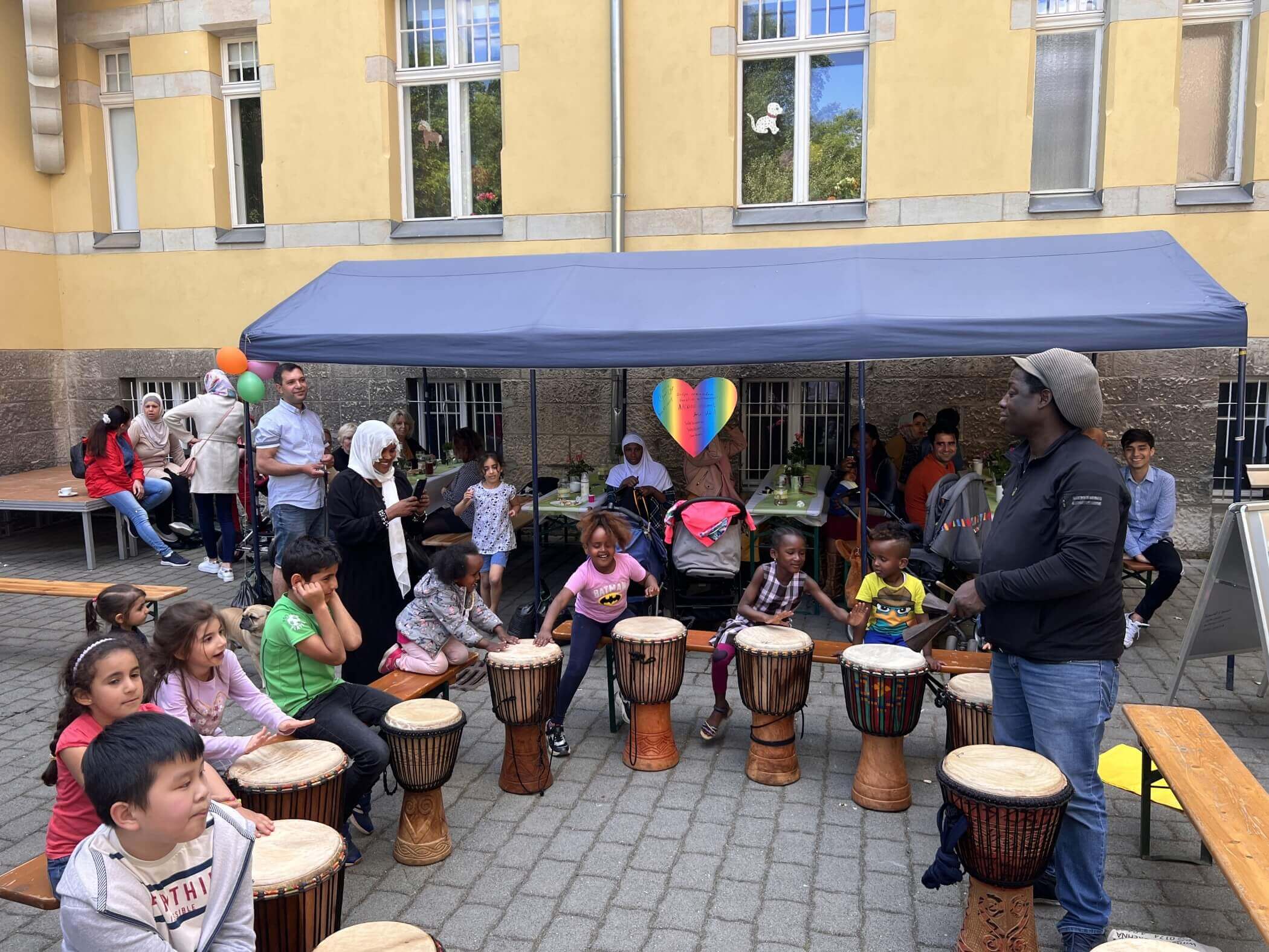 Trommeln stehen im Kreis und Menschen versammeln sich darum.
