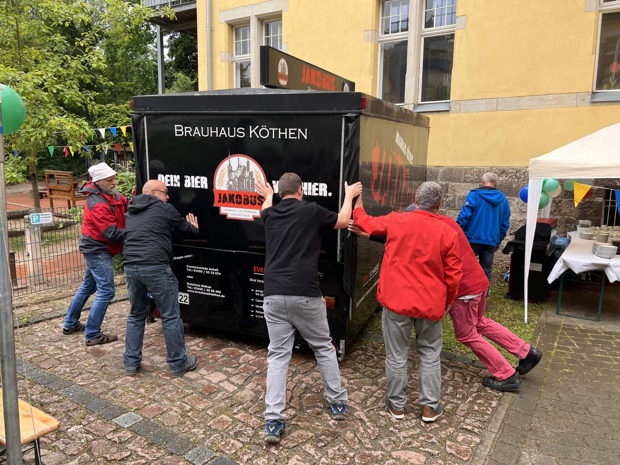 Menschen schieben einen Bierwagen in die richtig Position