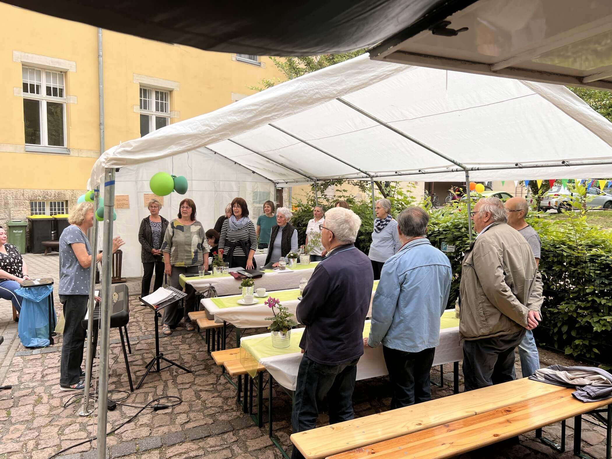 Ein Chor singt unter einem Festzelt