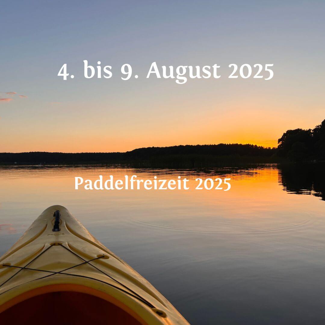 Die Spitze eines Kajaks auf dem Wasser bei Sonnenuntergang. Himmel und Wasser bilden einen Farbverlauf von Dunkelblau nach Orange